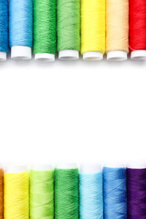 Multicolored sewing thread spools on white background