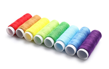 Multicolored sewing thread spools on white background