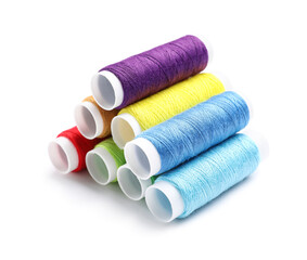 Multicolored sewing thread spools on white background