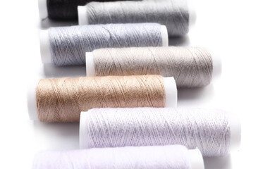 Multicolored sewing thread spools on white background