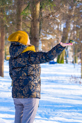 Photo of a bright little yellow tit sitting on the hand in winter park