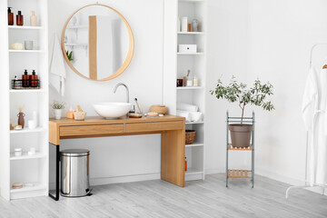 Fototapeta na wymiar Stylish interior of bathroom with shelf units and table with different bath supplies