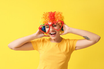 Funny young woman in disguise on yellow background. April fools' day celebration