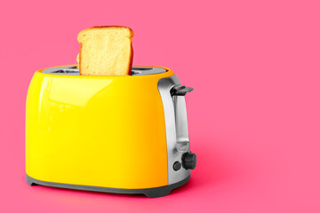 Modern toaster with bread slice on pink background