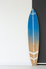 Blue surfboard near wall in room