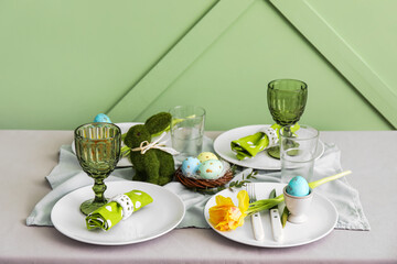 Table served for Easter celebration near green wall