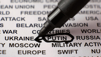 Closeup shot of PUTIN written on white paper with a black circle and arrow. Russian invasion of...