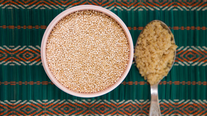 container with raw quinoa and a tablespoon of cooked quinoa