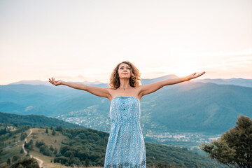 Fototapeta na wymiar Woman traveler posing with raising arms relaxing on viewpoint. Perfect slim body woman. Portrait of lady enjoying her vacation. Beautiful landscape, travel