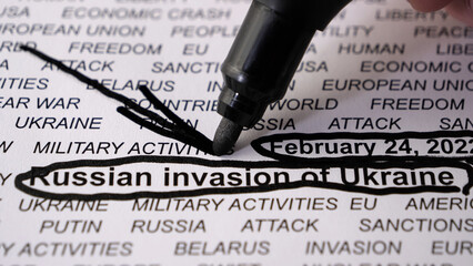 Closeup shot of Russian invasion of Ukraine written on white paper. Black circles and text. Arrow....