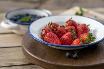 strawberries in a bowl on a wooden table