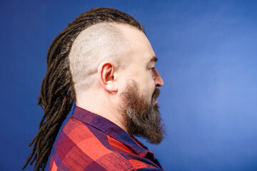 Adult male with mohawk and dreadlocks in profile. A middle-aged man with a beard and an unusual...