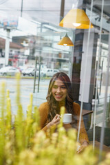 coffee shop interior a beautiful young latin woman with long blonde hair sitting enjoying a cup of coffee, modern lifestyle, model joy with elegant decoration, beauty and drink