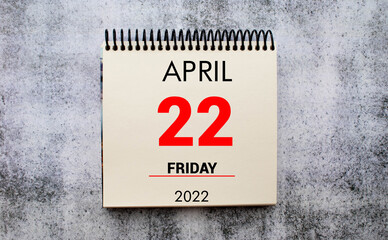 Obraz premium April 22. 22th day of month, calendar date. Stand for desktop calendar on beige wooden background.