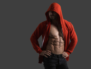 Fototapeta na wymiar Male bodybuilder in a hood on a black background. Naked male torso, chest muscles and abs. Banner poster.
