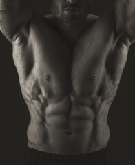 Fototapeta na wymiar Male torso. Close-up of chest and abs muscles. Black and white photo. Banner poster.