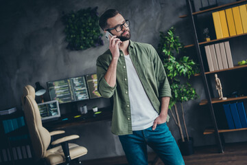 Photo of attractive positive young guy dressed khaki shirt glasses communicating modern gadget...