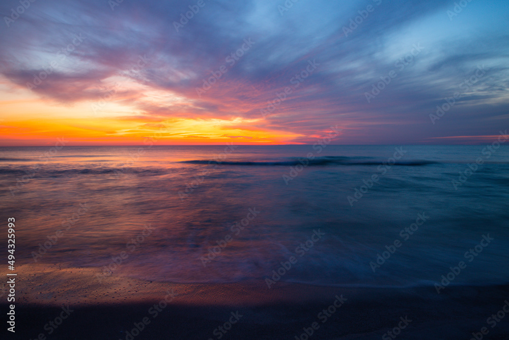 Wall mural Beautiful view of the sea with waves at orange sunset