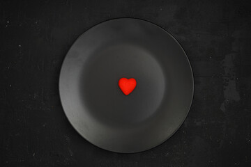 Creative concept food holiday valentines day love photo of heart on plate dish on black background.