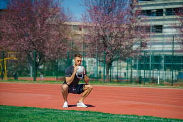 Obraz premium Young muscular man doing exercises with kettlebell outdoor. Weightlifting workout. Sports, fitness concept.