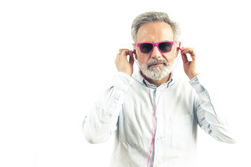 Caucasian bearded middle-aged man wearing fuscia sunglasses and earphones portrait isolated studio shot copy space . High quality photo