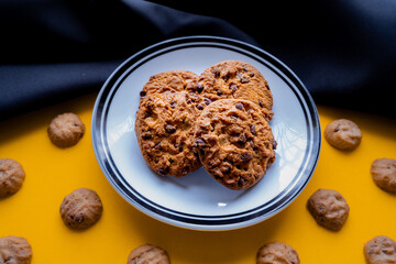 chocolate cookies on a plate with a yellow and black background 