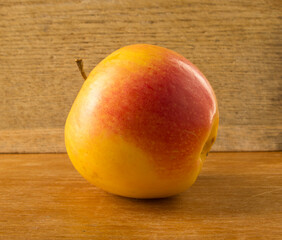 beautiful yellow-red apple on the background of a wooden board close-up