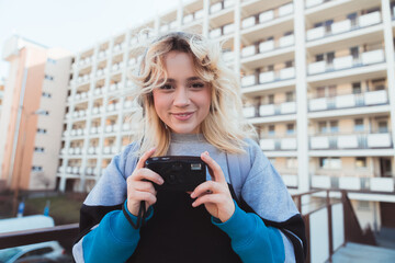 Cheerful teenage girl holding retro vintage analog camera and looking at camera. 90s vibes. High quality photo