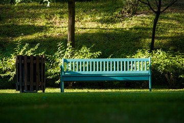 a blue birch bench in a park in a beautiful green area with grass trees a lonely bench without people