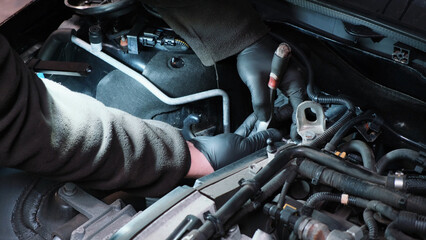 Engine repair in an automobile. Auto mechanic in a car repair center. Replacement of automobile oil...