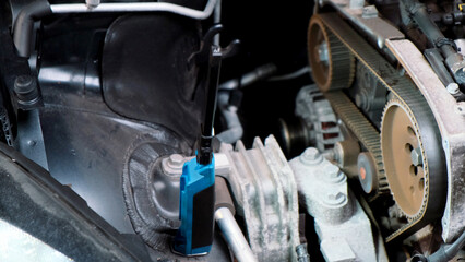 Replacing the engine timing belt in an automobile. Auto mechanic in a car repair center. Replacement of automobile oil and filter