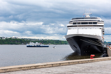  The Saint Lawrence river with a cruise ship and the ferry between Quebec city and Levis under a stormy sky at the beginning of the summer.