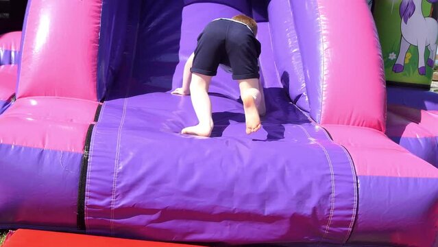 Small Boy having fun playing on a Bouncy Castle