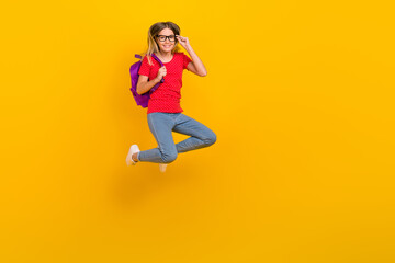 Fototapeta na wymiar Full size photo of young cheerful lady hold backpack eyewear lesson jumper isolated over yellow color background