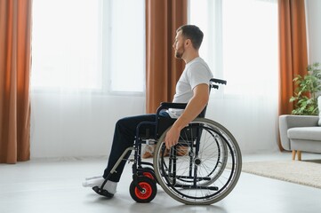 Young handsome man in wheelchair - obrazy, fototapety, plakaty