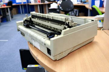 Photo of old and worn dot matrix printer on office desk