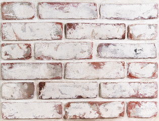 Grungy brick wall with remnants of whitewash and natural defects, front view. It can be used as...