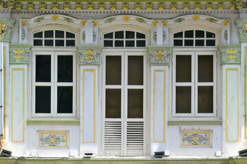Singapore Straits Chinese Peranakan shophouse with arched windows, white louvers,ornate columns