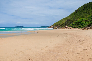 Fototapeta na wymiar Sandy beach with amazing rocks and ocean. Holiday banner in Brazil, Floripa