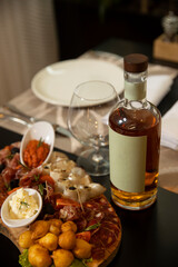 Fototapeta na wymiar Mockup bottle of whiskey served with food on a restaurant table
