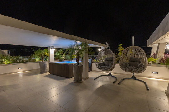 Two egg chair swing on a luxury terrace in the evening