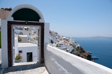 Open front door with a view of Santorini village and the Aegean Sea, Greece.