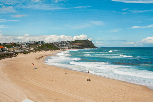 Scenic view of sandy beach and blue wavy ocean on a sunny day in Newcastle, Merewether