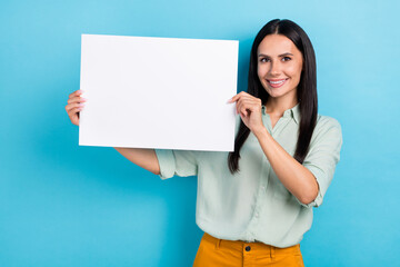 Photo of young pretty cheerful woman hold paper poster news advertise isolated over blue color background