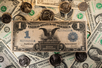 Black Eagle Dollar banknote on top of rare US Dollar banknotes and coins