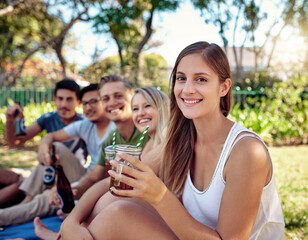 Having the best time ever. Cropped portrait of an attractive young woman enjoying a few drinks with friends outside in the summer sun.