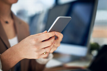 Building business with her extensive network. Closeup shot of an unrecognizable businesswoman using her cellphone in an office.