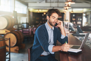 Working on his blog in his favourite bar. Cropped shot of a handsome young man using his laptop and...