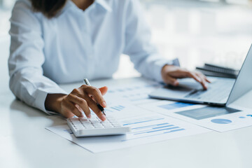 Female businesswoman readind financial report analyzing statistics pointing at pie chart working at her desk