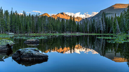 Longs Peak at Nymph Lake - Panoramic view of majestic Longs Peak, with golden sunset light shining...